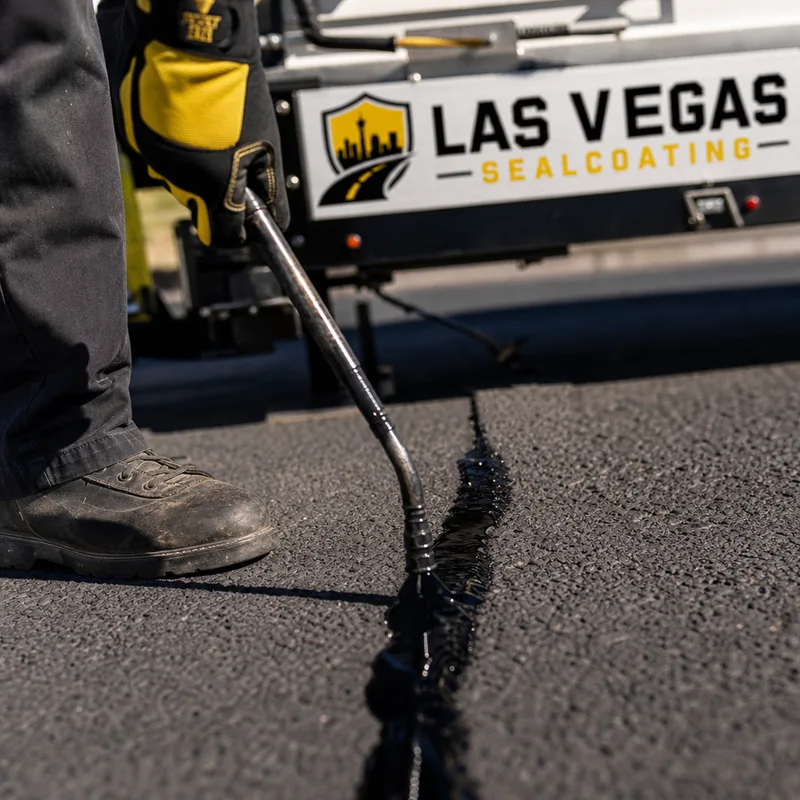 Close-up of a cleaned crack being filled with hot rubberized crack sealant with controlled application and full penetration